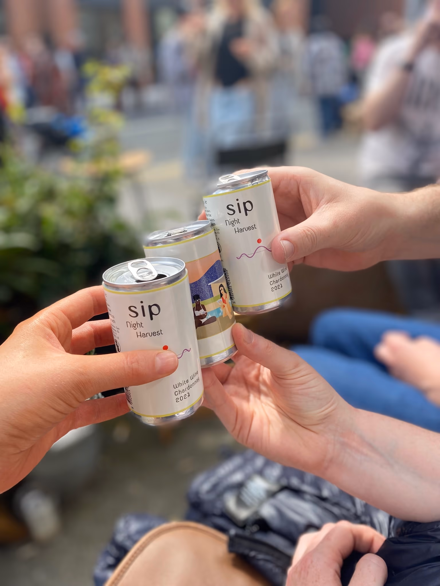 Three friends cheers with SIP Night Harvest cans